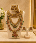 Temple bridal jewellery set with antique gold finish, Lakshmi motifs, ruby and green stones, pearl detailing, matching earrings, and maang tikka.